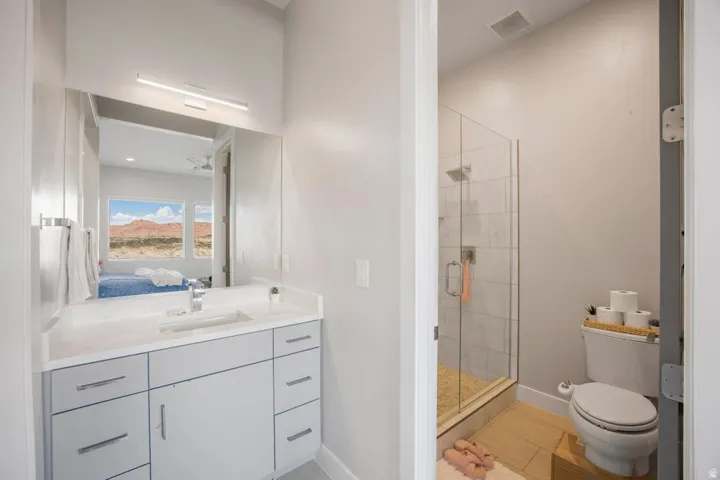 Vanity with an integrated sink, modern cabinetry, and wall-mounted light bar