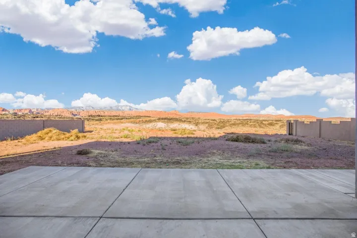 Expansive concrete patio with block wall perimeter, set against a desert landscape with distant mountains