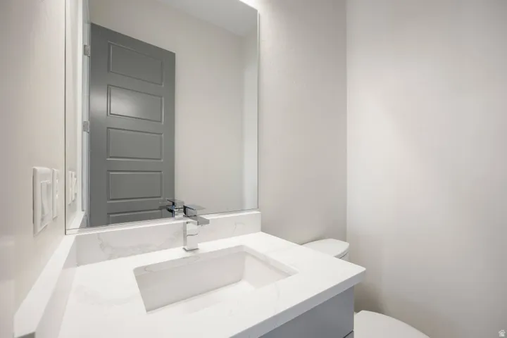 Vanity with an integrated rectangular sink, chrome-finish faucet, and a large wall-mounted mirror
