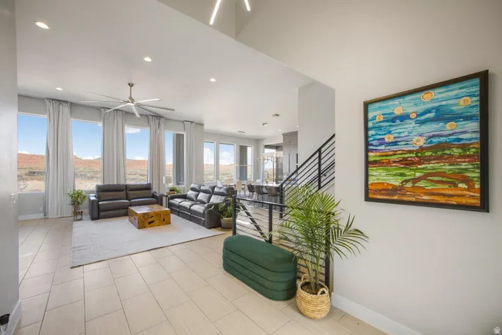 Open-concept living area with high ceilings, recessed lighting, and large windows