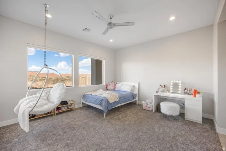 Recessed lighting, ceiling fan, and large windows with roller shades