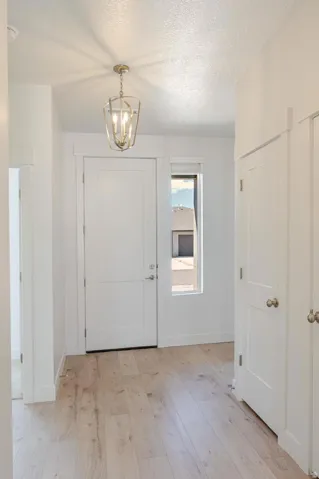 Light wood-finish flooring with a side window and a ceiling-mounted light fixture