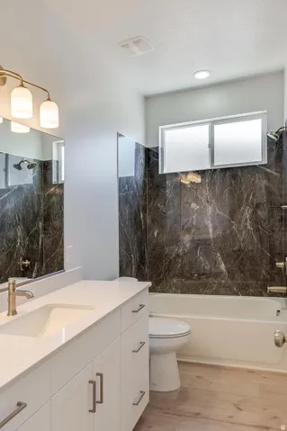 White vanity with a single basin sink and brushed nickel faucet