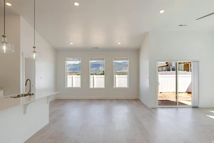 Open concept living space with wood-finish flooring, recessed lighting, and a vaulted ceiling