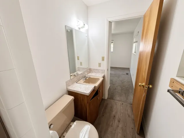 Vanity with a solid surface countertop, integrated sink, and wood-finish cabinetry