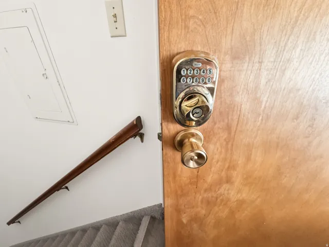 Wood-finish door with a digital keypad lock and brass-tone doorknob