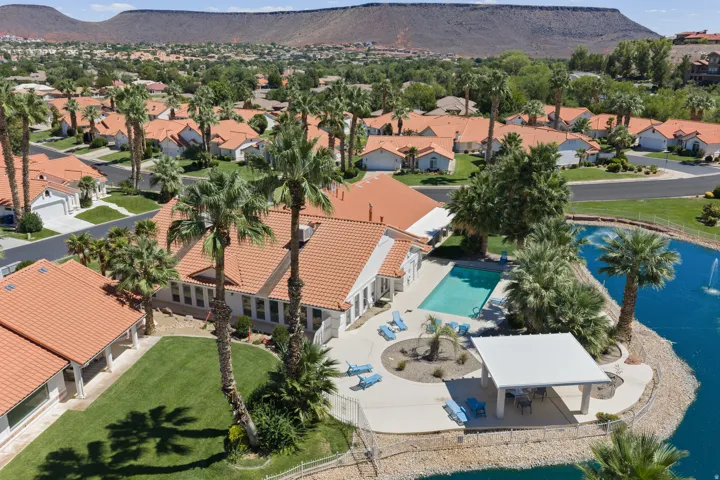 Community pool with surrounding patio, covered outdoor seating area, and adjacent water feature with fountain