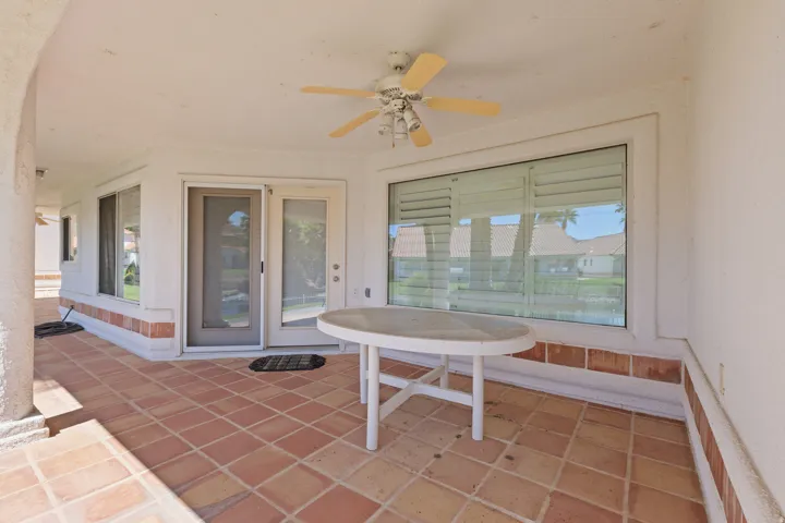 Covered patio featuring terra cotta tile flooring, a ceiling fan, and sliding glass door access