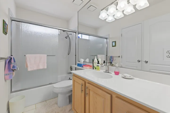 Vanity with a white countertop and light wood-finish cabinetry