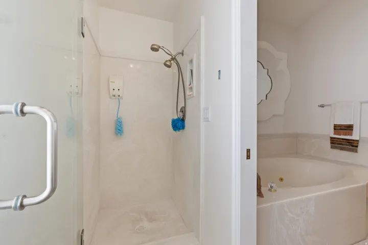 Walk-in shower with clear glass enclosure and dual shower heads