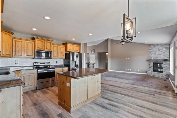 Kitchen featuring wood cabinetry, stainless steel appliances, and a central island with a granite countertop