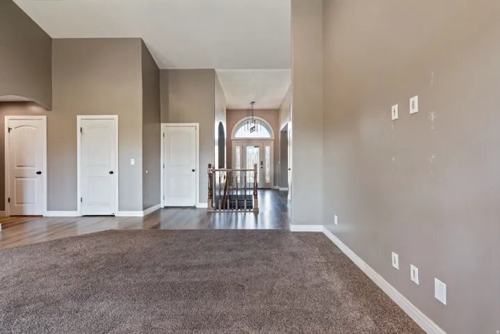 High ceilings, neutral-toned walls, and wood-finish flooring