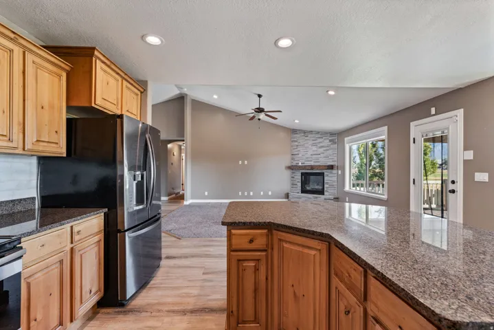 Kitchen with wood cabinetry, stainless steel appliances, and granite countertops
