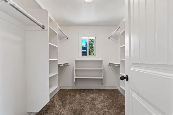 Custom closet organization system with multiple shelving units and hanging rods