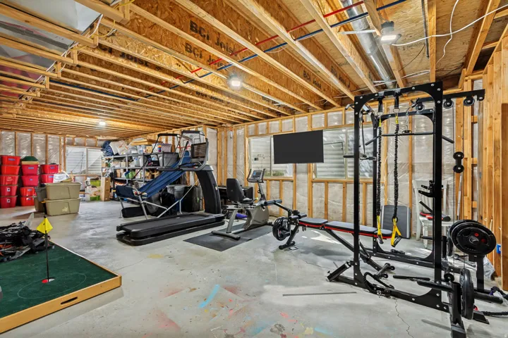 Unfinished basement with exposed wood joists and concrete flooring