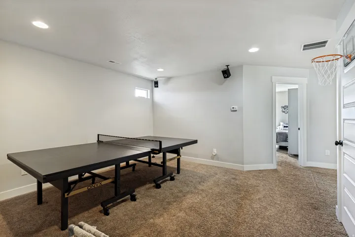 Recessed lighting, light-toned walls, and neutral carpeting