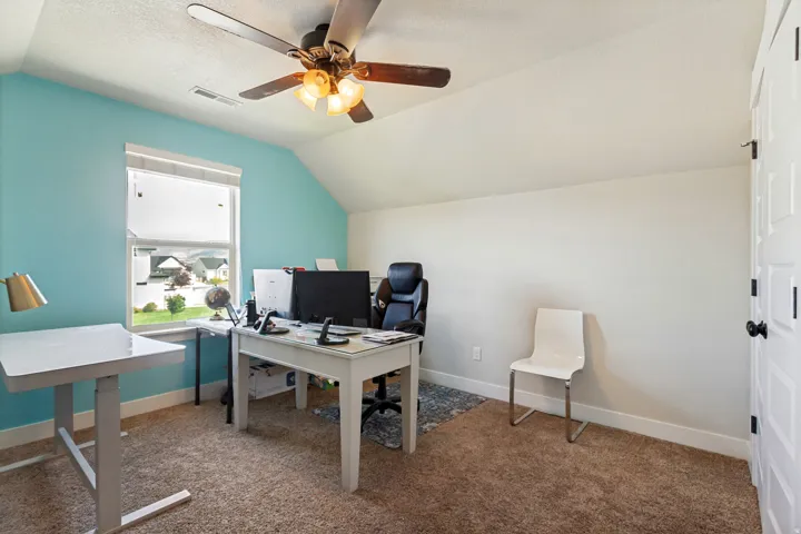 Vaulted ceiling with a ceiling fan, window with blinds, and white paneled door