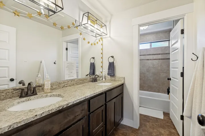 Dual vanity with light-colored countertop and dark wood-finish cabinetry