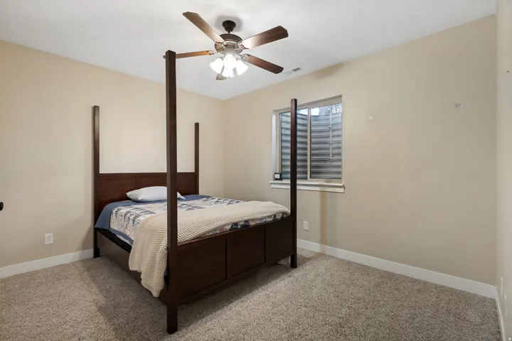 Carpeted flooring, neutral wall tones, and a ceiling fan with integrated lighting