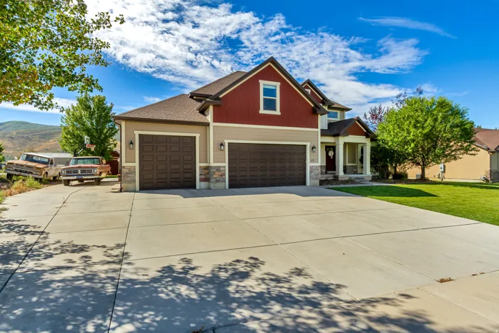 Two-story property featuring a multi-tone exterior, attached two-car garage, and a covered front entry