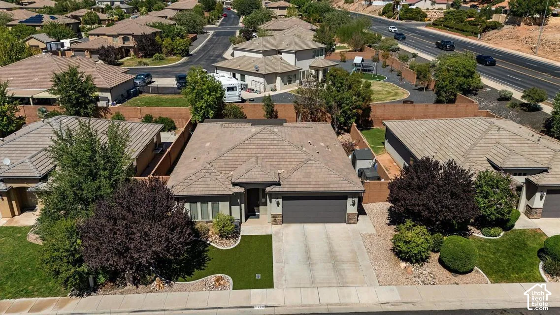 Property features a tiled roof, attached garage, and a neatly landscaped front yard with artificial turf and mature shrubs