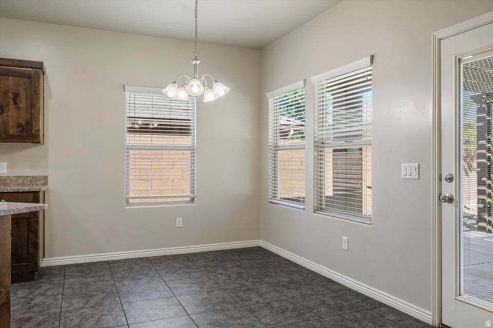 Tile flooring, multiple windows with blinds, built-in cabinetry, and a ceiling light fixture