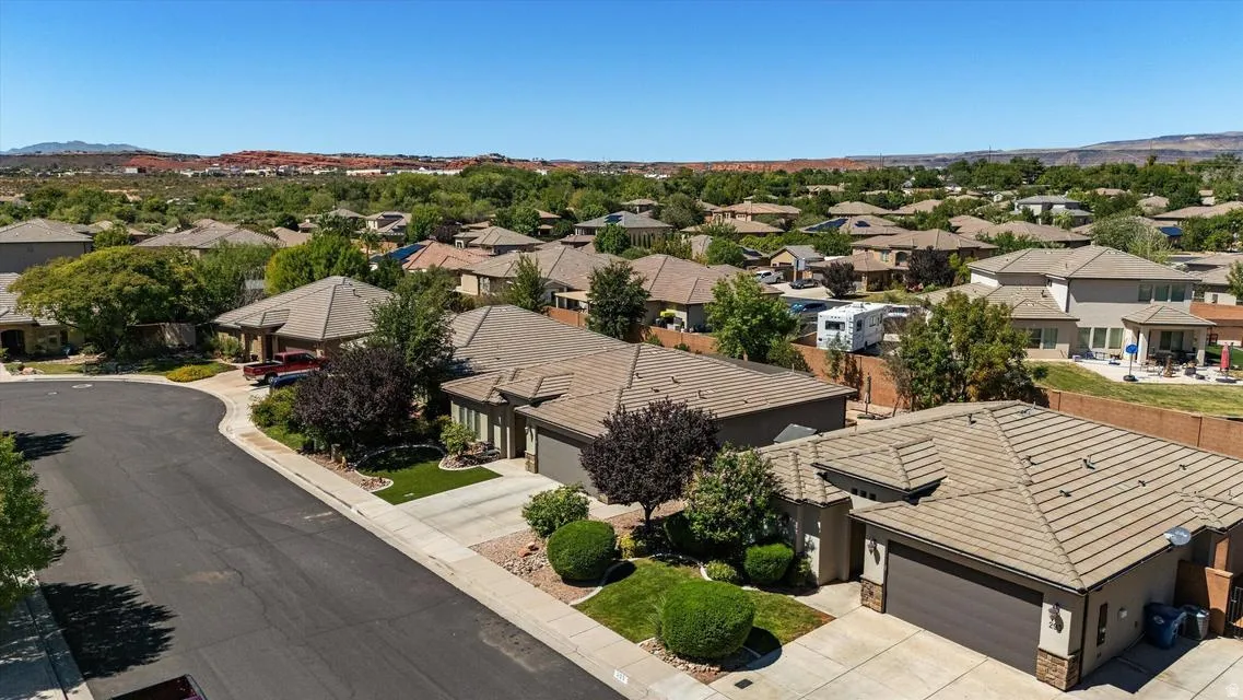 Residential street with a curved asphalt road, concrete sidewalks, and mature landscaping