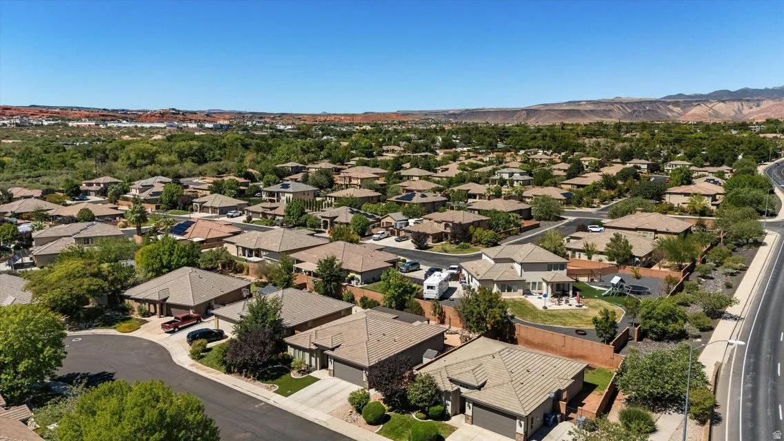 Residential neighborhood with a range of single-story and two-story homes, diverse landscaping, and a clear sky backdrop