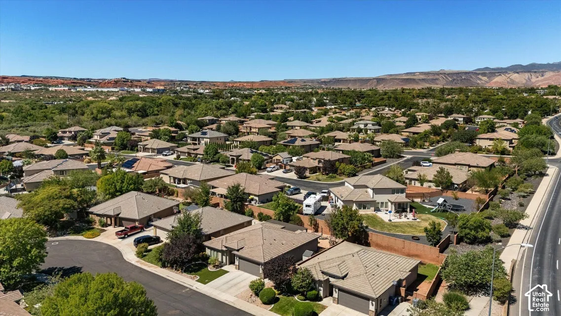 Residential neighborhood with a range of single-story and two-story homes, diverse landscaping, and a clear sky backdrop