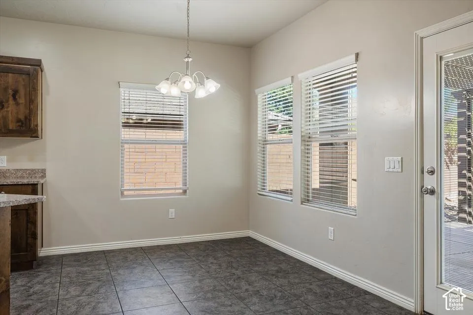 Tile flooring, multiple windows with blinds, built-in cabinetry, and a ceiling light fixture