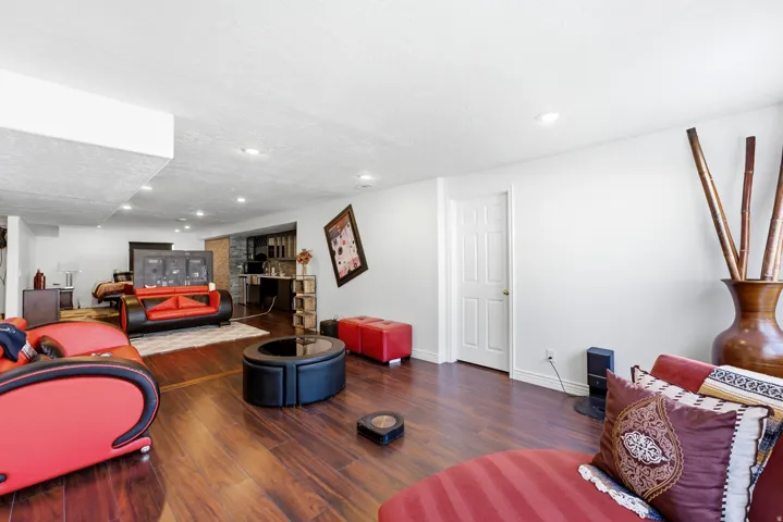 Wood-finish flooring, recessed lighting, white panel door, and white painted walls