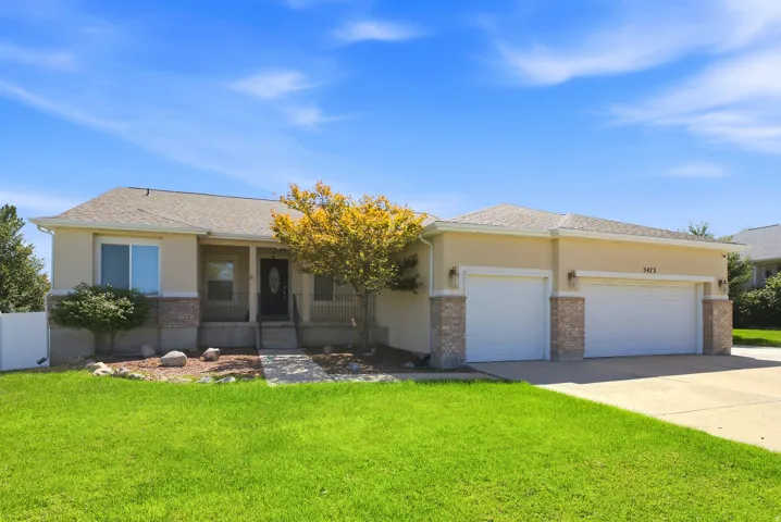 Stucco exterior with stone accents, covered front porch, and an attached two-car garage