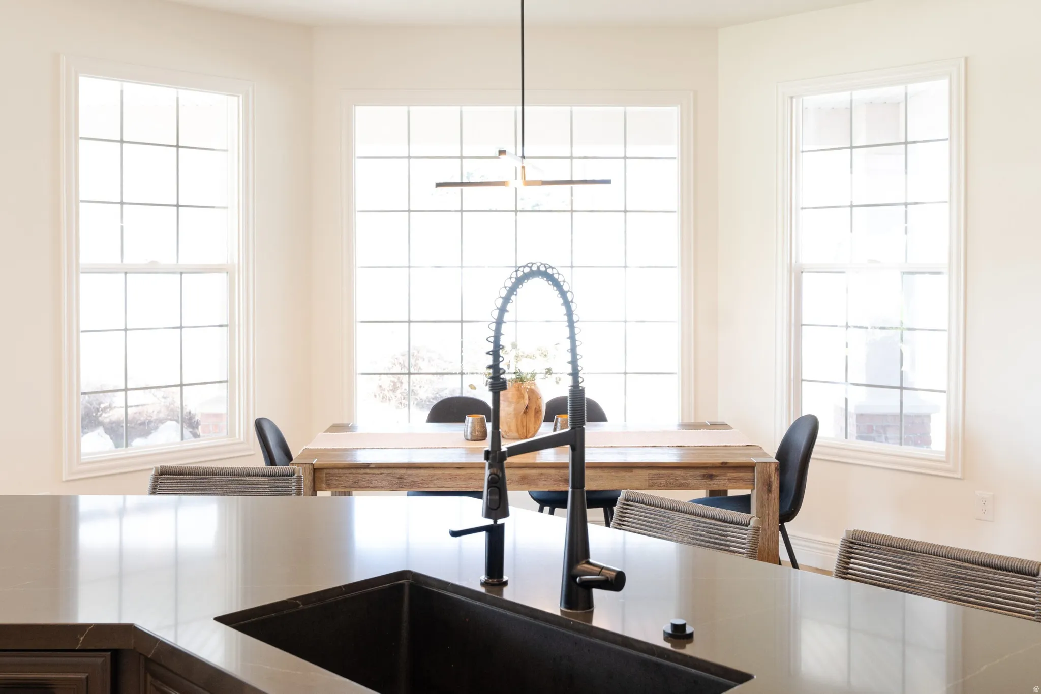 Large kitchen island with a dark sink and matte black faucet