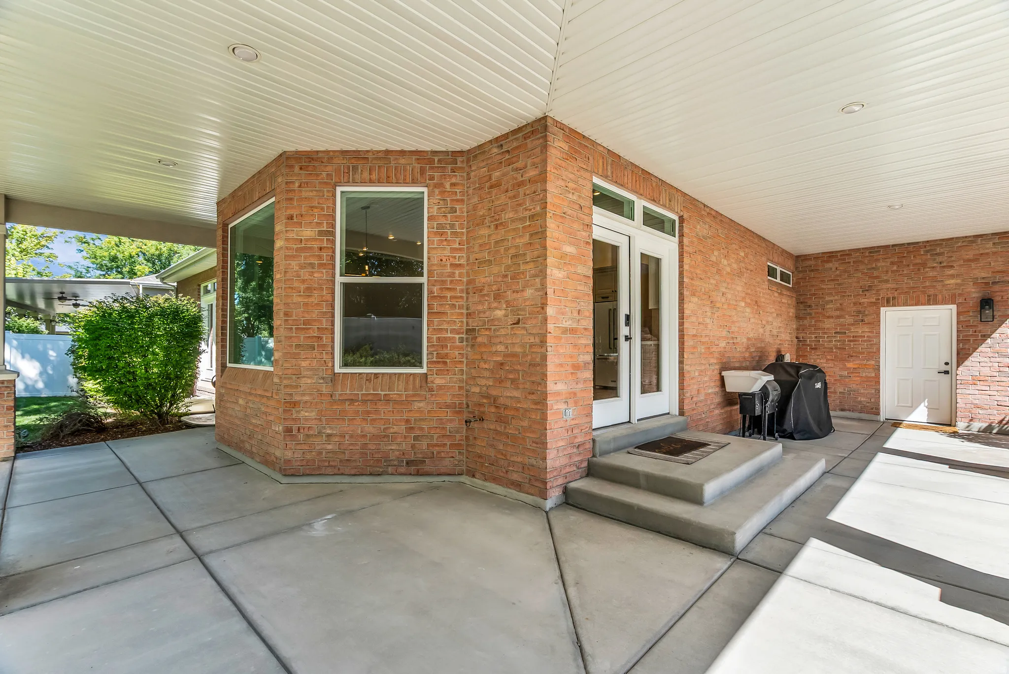 Covered patio with a brick exterior, recessed lighting, and a white paneled ceiling