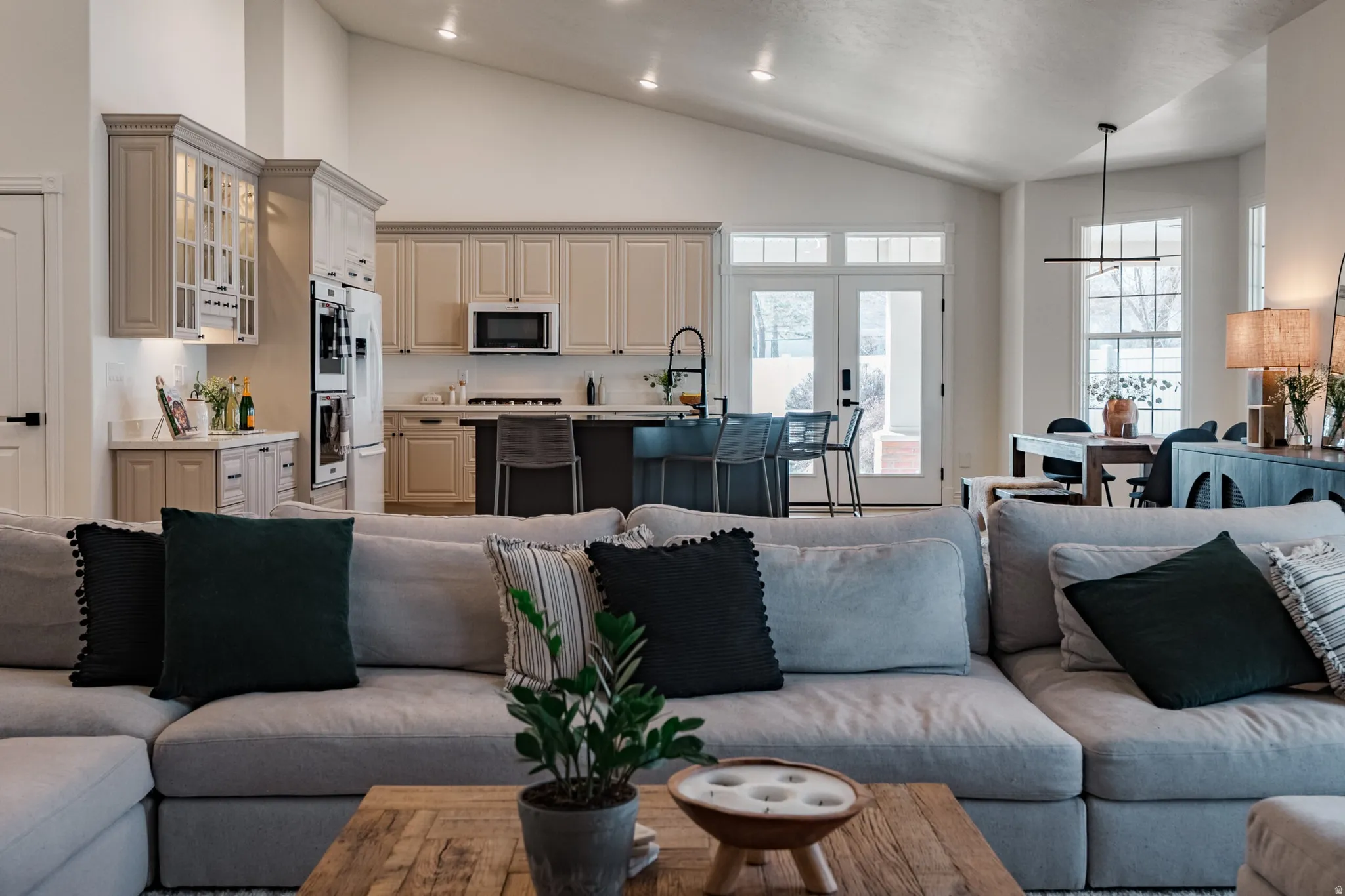 Vaulted ceilings, recessed lighting, double ovens, and a kitchen island with seating