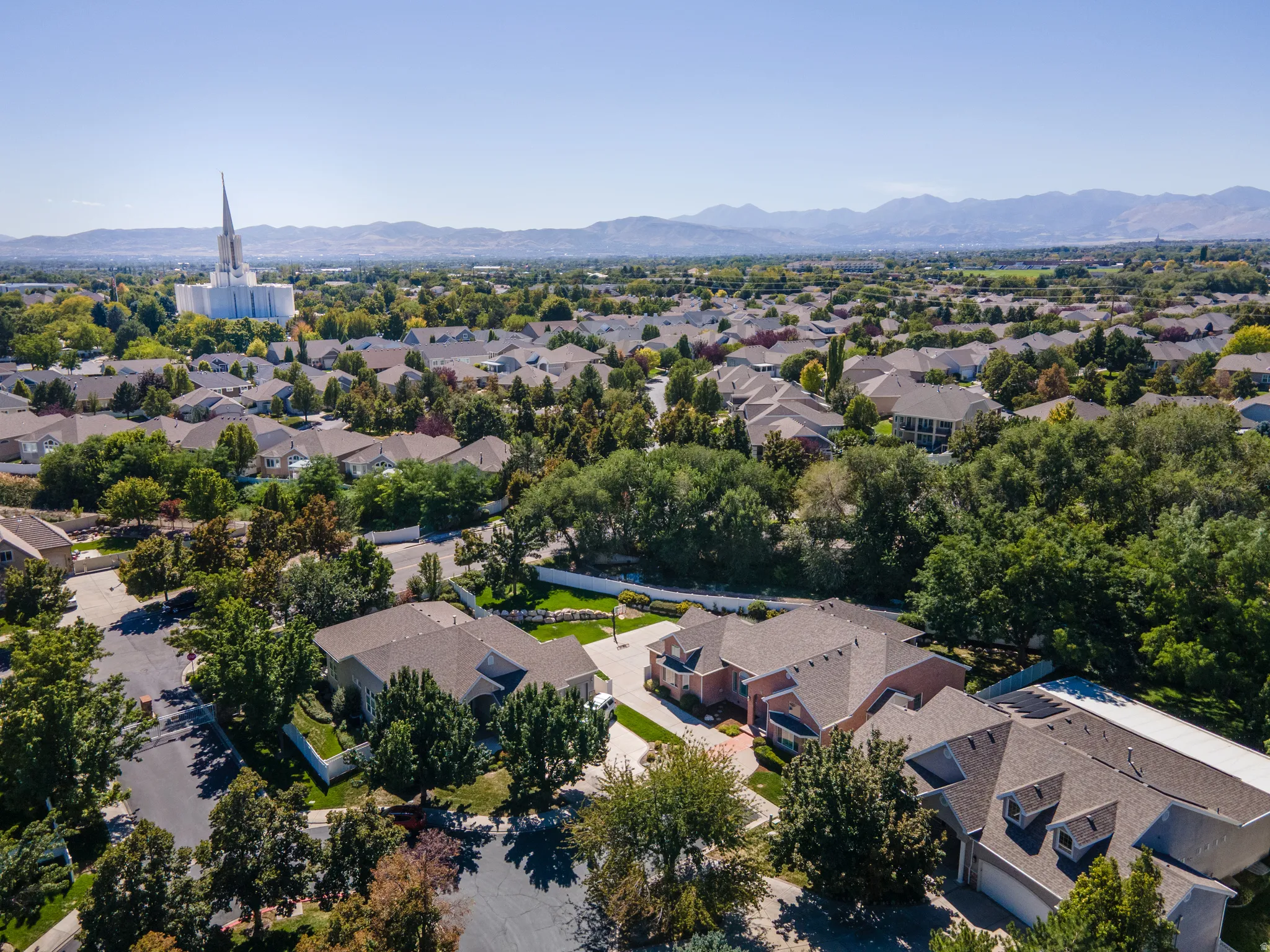 Residential neighborhood with mature trees and mountain backdrop