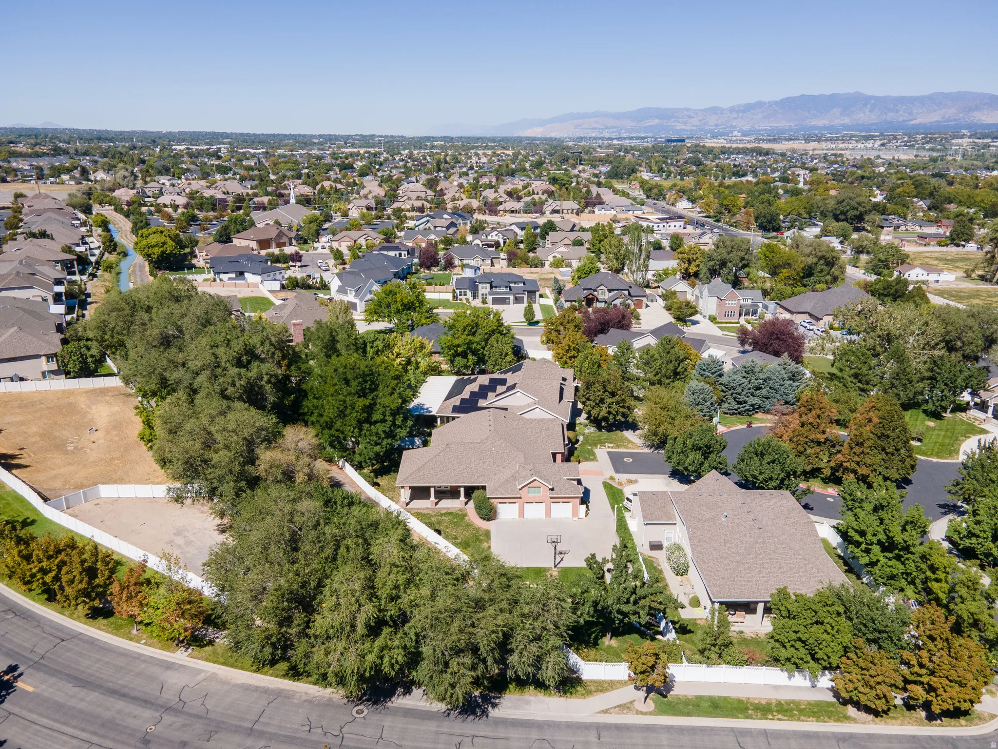 Residential property featuring a light-toned exterior, an attached multi-car garage, and a paved driveway