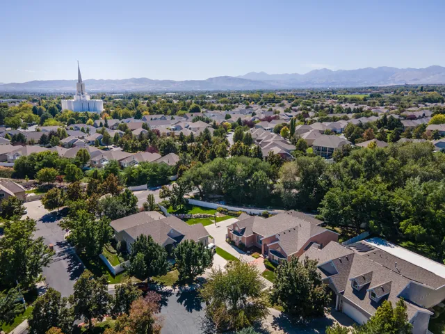 Residential neighborhood with mature trees and mountain backdrop