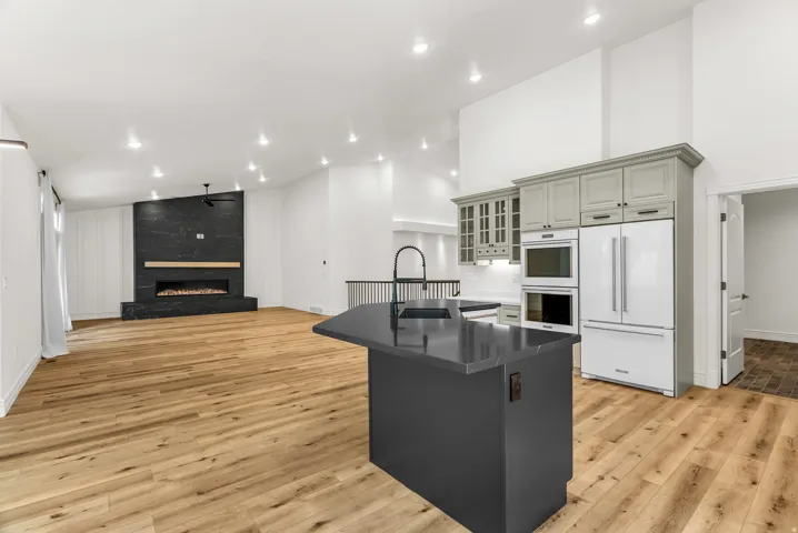 Open-concept living space with vaulted ceilings, wood-finish flooring, and recessed lighting