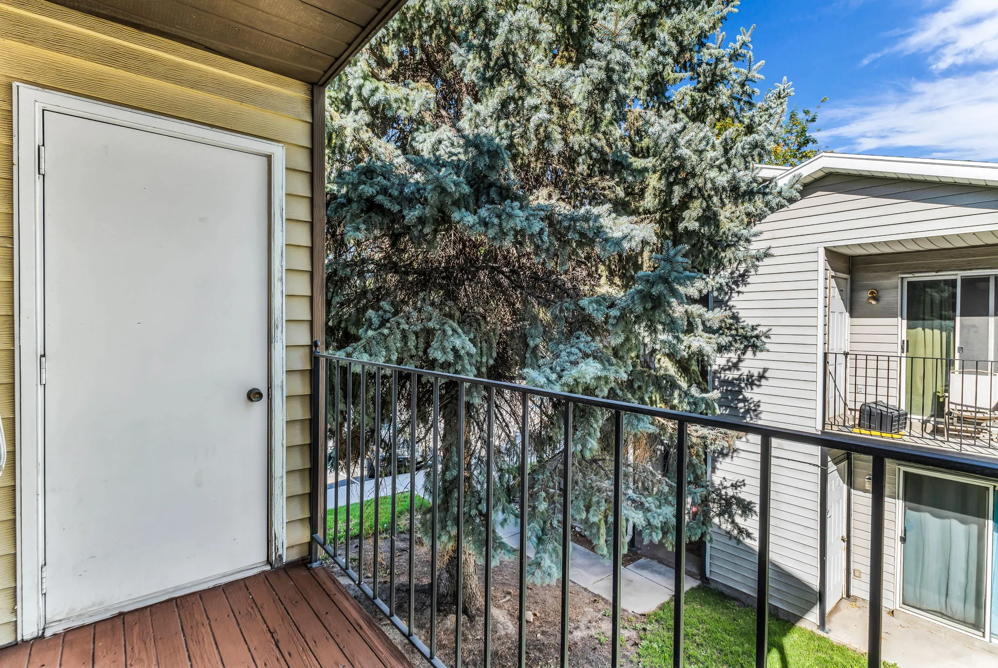 Private balcony featuring wood-finish flooring and a black metal railing