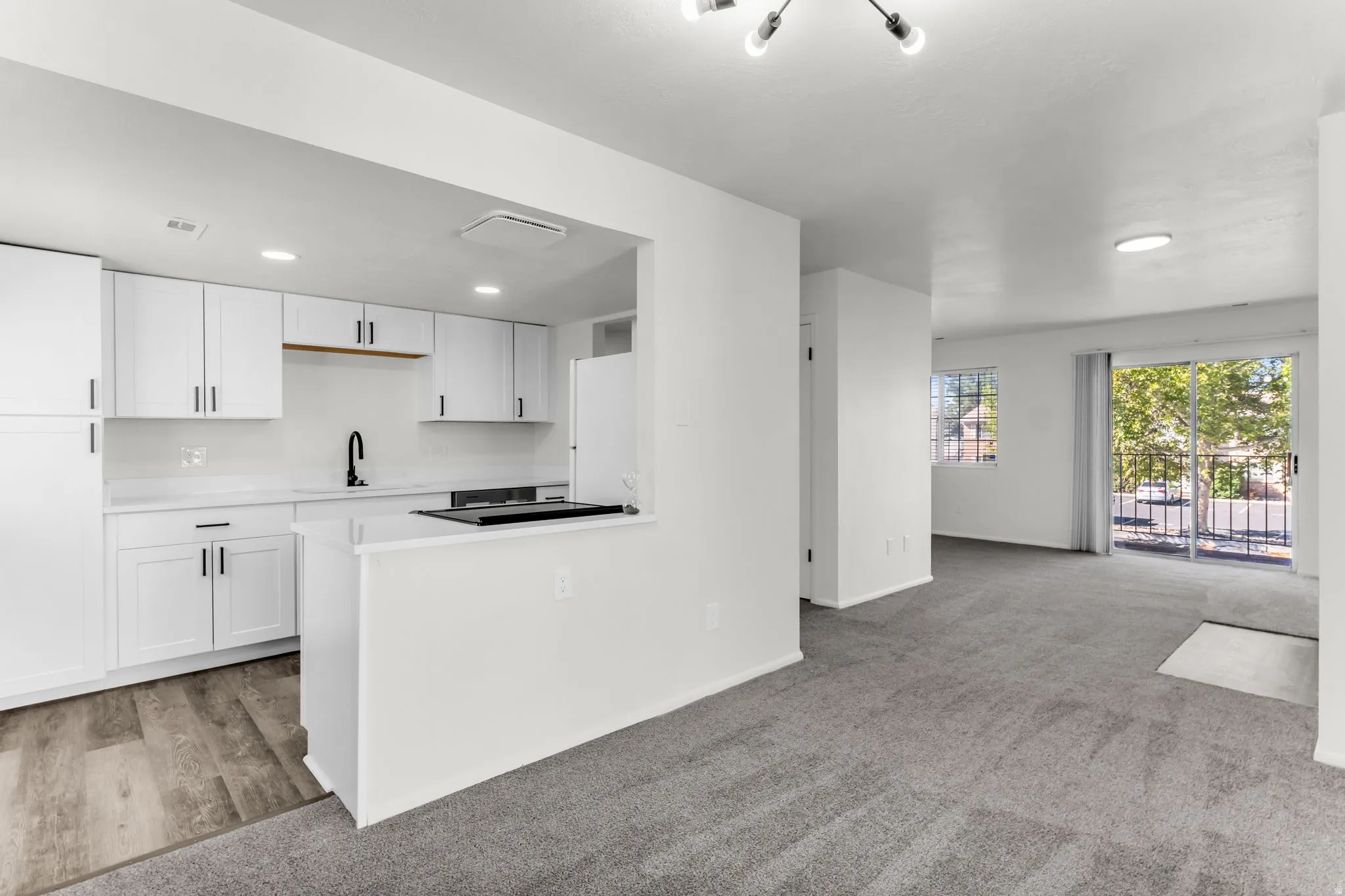 White cabinetry and countertops in the kitchen area