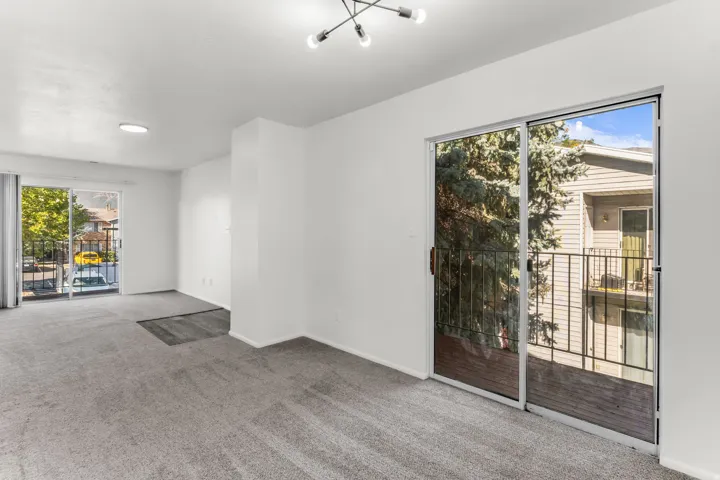 Light gray carpeting throughout, white painted walls, recessed ceiling lighting, and a contemporary ceiling fixture