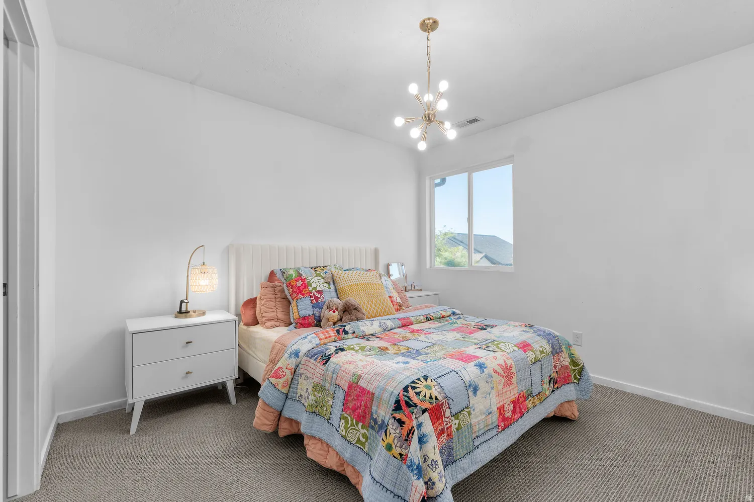 White walls with a window, carpeted flooring, and a modern ceiling light fixture