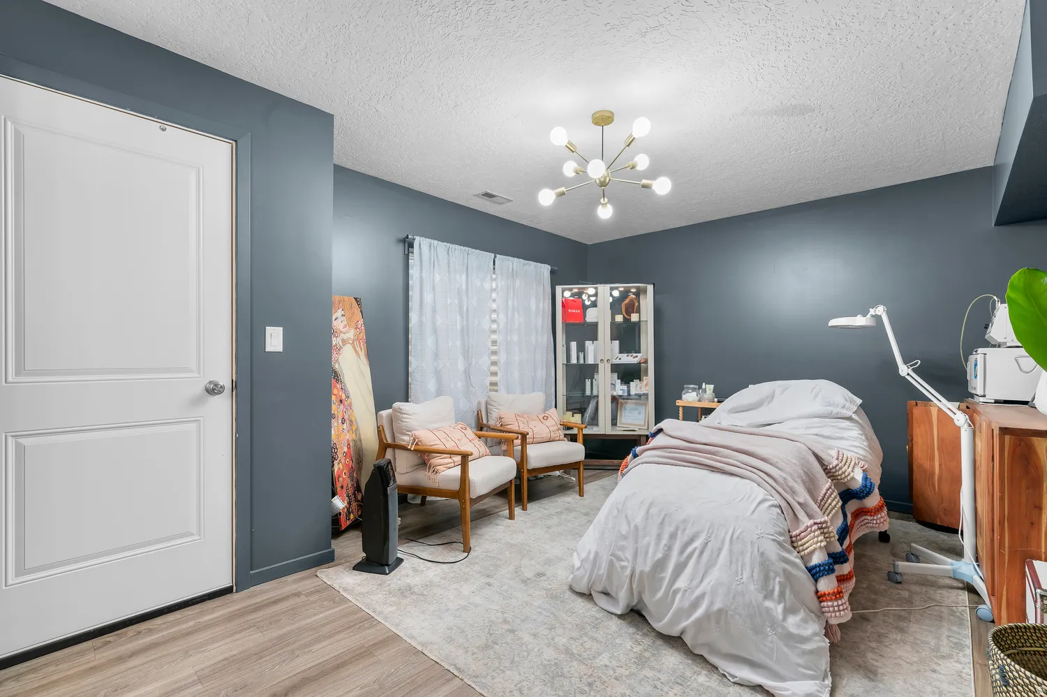 Recessed ceiling, wood-finish flooring, and a modern sputnik-style chandelier