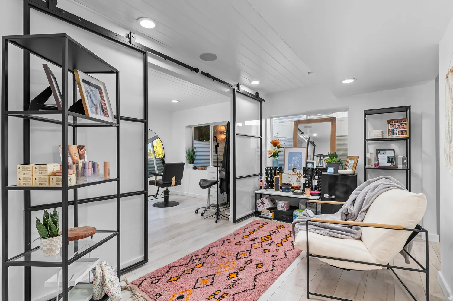 Sliding barn doors with frosted glass panels, recessed ceiling lighting, light wood-finish flooring, white shiplap ceiling, and built-in shelving with metal frames
