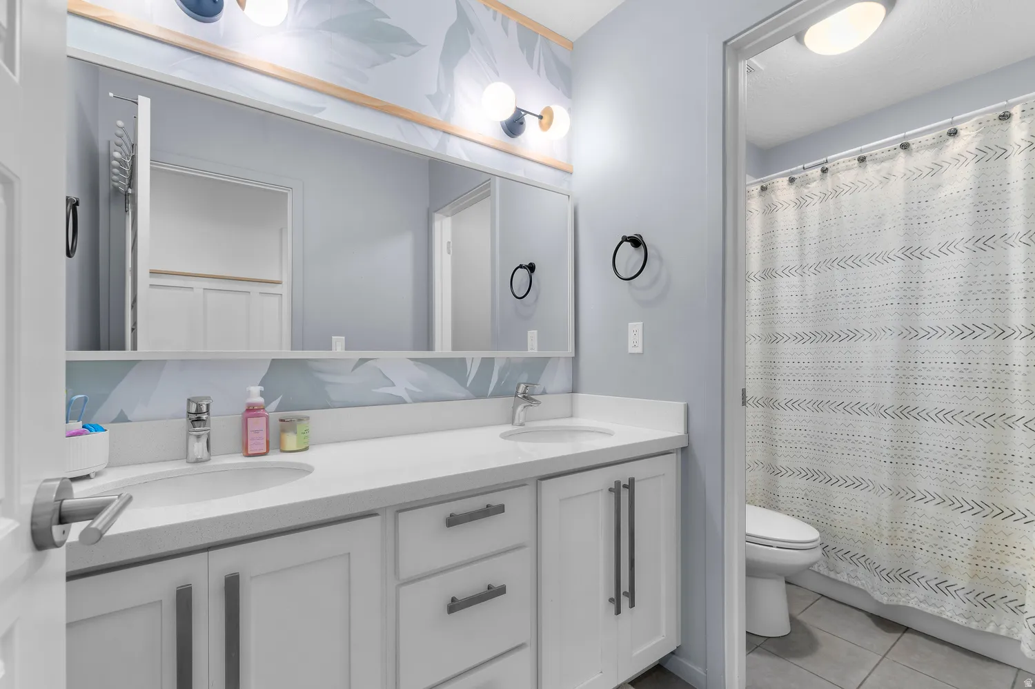 Double vanity with integrated sinks, white cabinetry, and matte black hardware