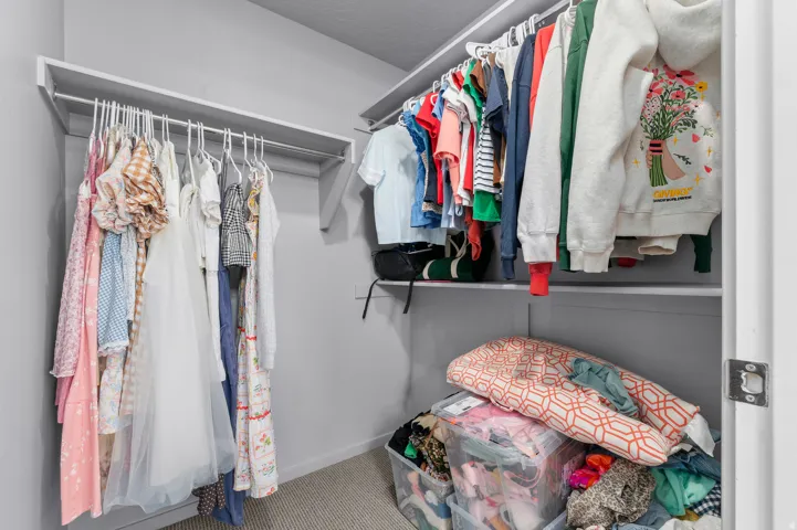 Walk-in closet featuring built-in shelving and hanging rods