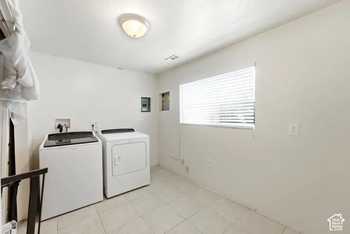 Laundry area featuring tiled flooring, a window with blinds, and an overhead light fixture