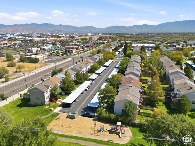 Aerial perspective showcasing multiple properties with covered parking structures, adjacent to a public park with playground equipment