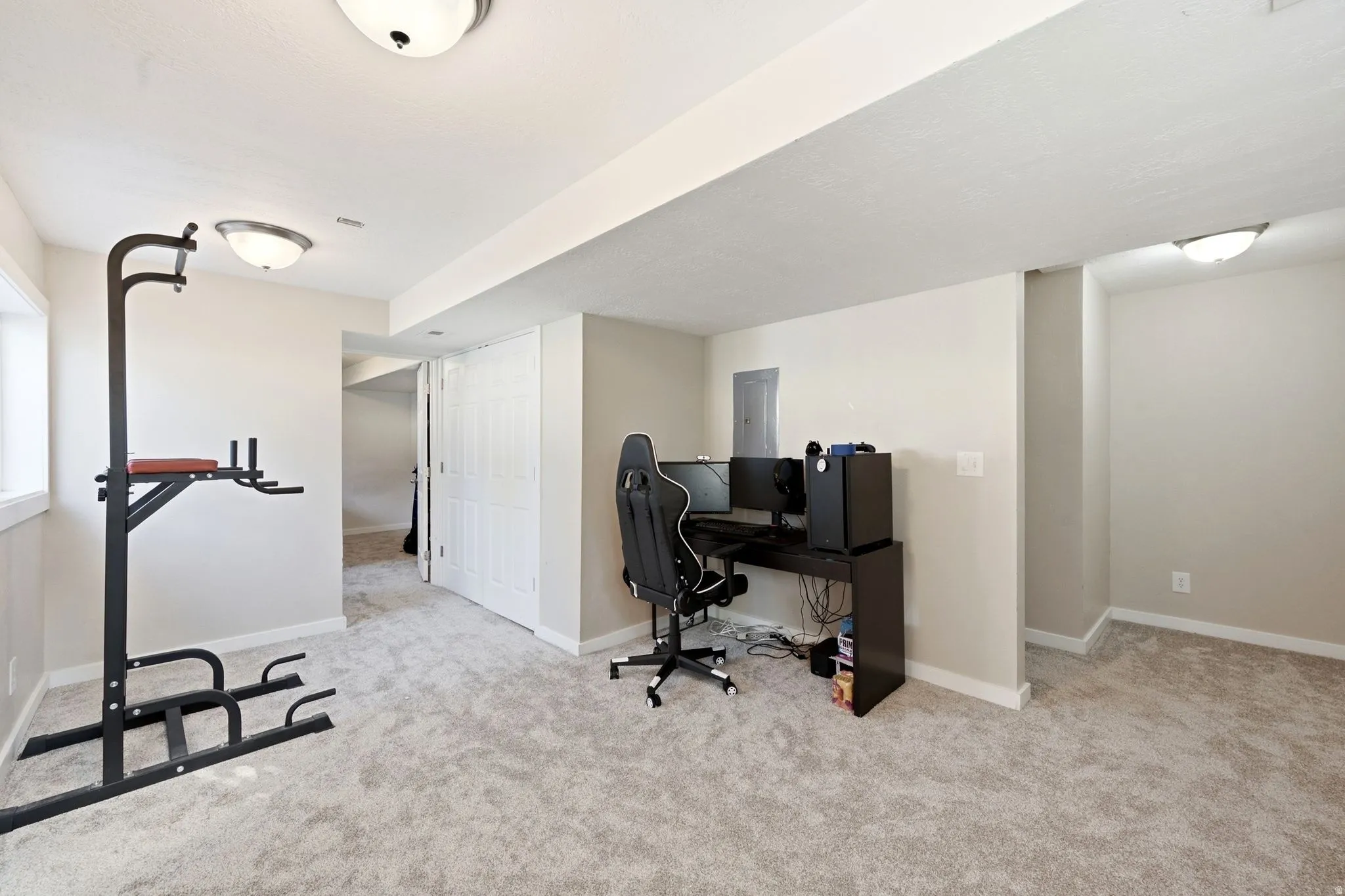 Carpeted interior space featuring neutral wall tones, overhead dome lighting, white trim, and a white bi-fold door